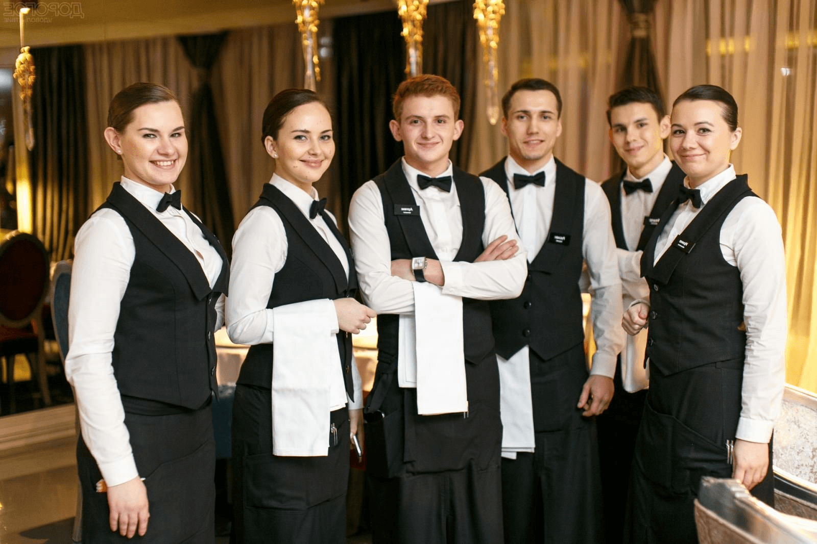 A hospitality team lined up together in a restaurant